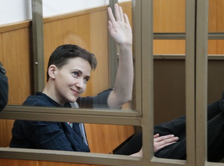 A defiant Nadezhda Savchenko waves at assembled media in court