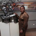 Sokari Douglas Camp CBE posing with one of her sculptures exhibited at the Enterprise Minds Awards 2016